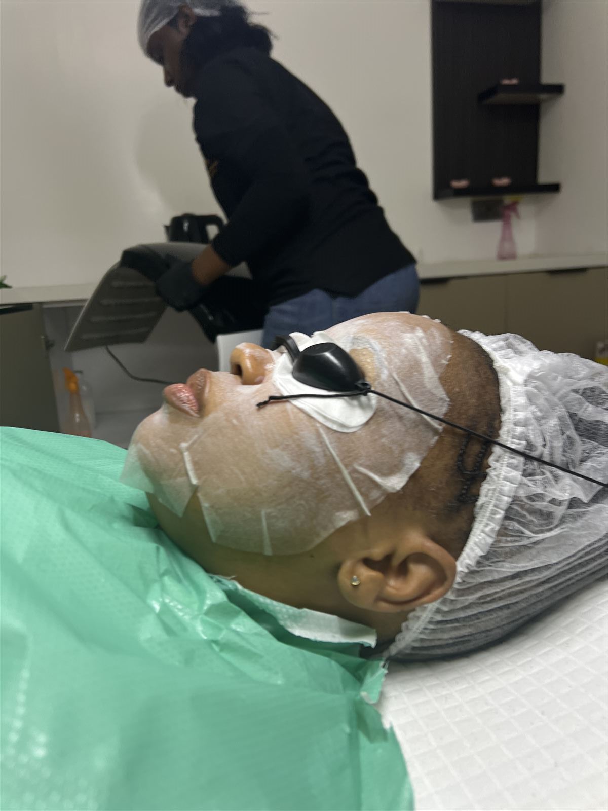 A client during a sheet-mask and light treatment